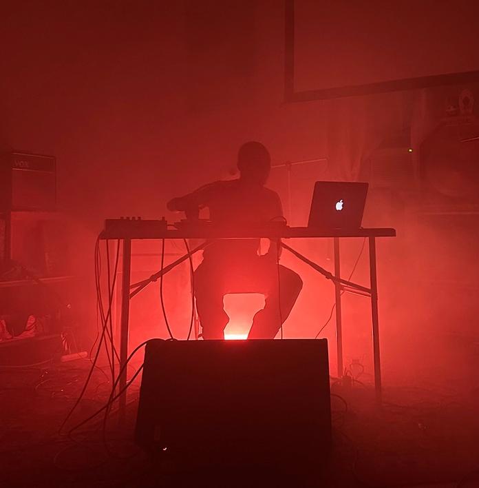 a man is sitting at a desk with a laptop in a dark room .