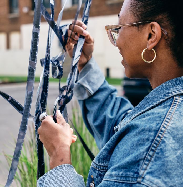 a woman in a denim jacket is holding a roll of film .