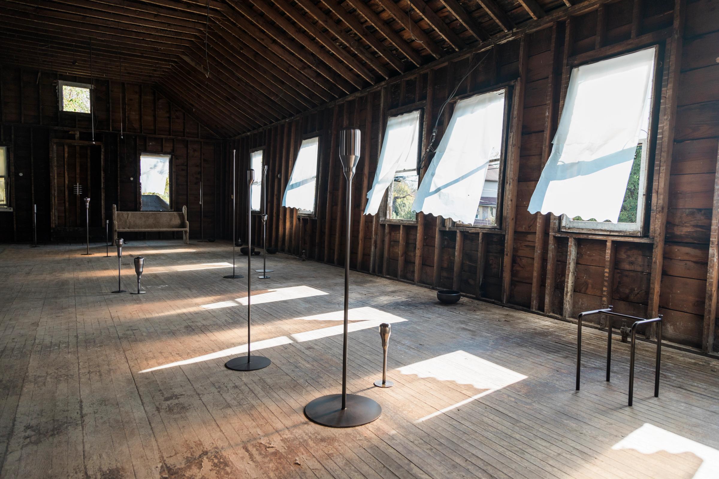 a room with a lot of windows and candles on the floor .