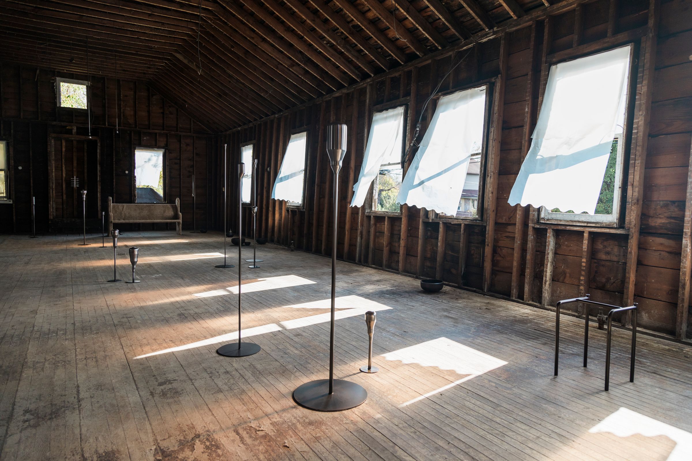 a room with a lot of windows and candles on the floor .