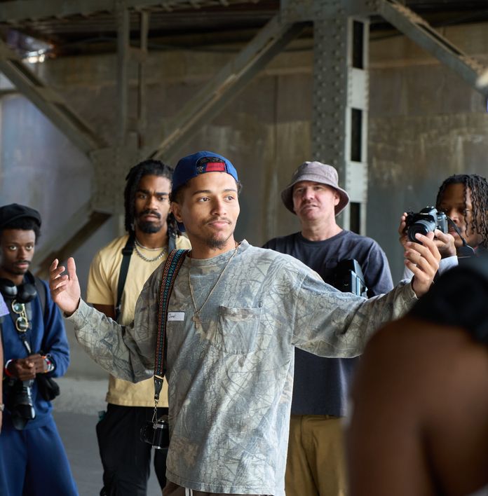 a group of men are standing around a man holding a camera .