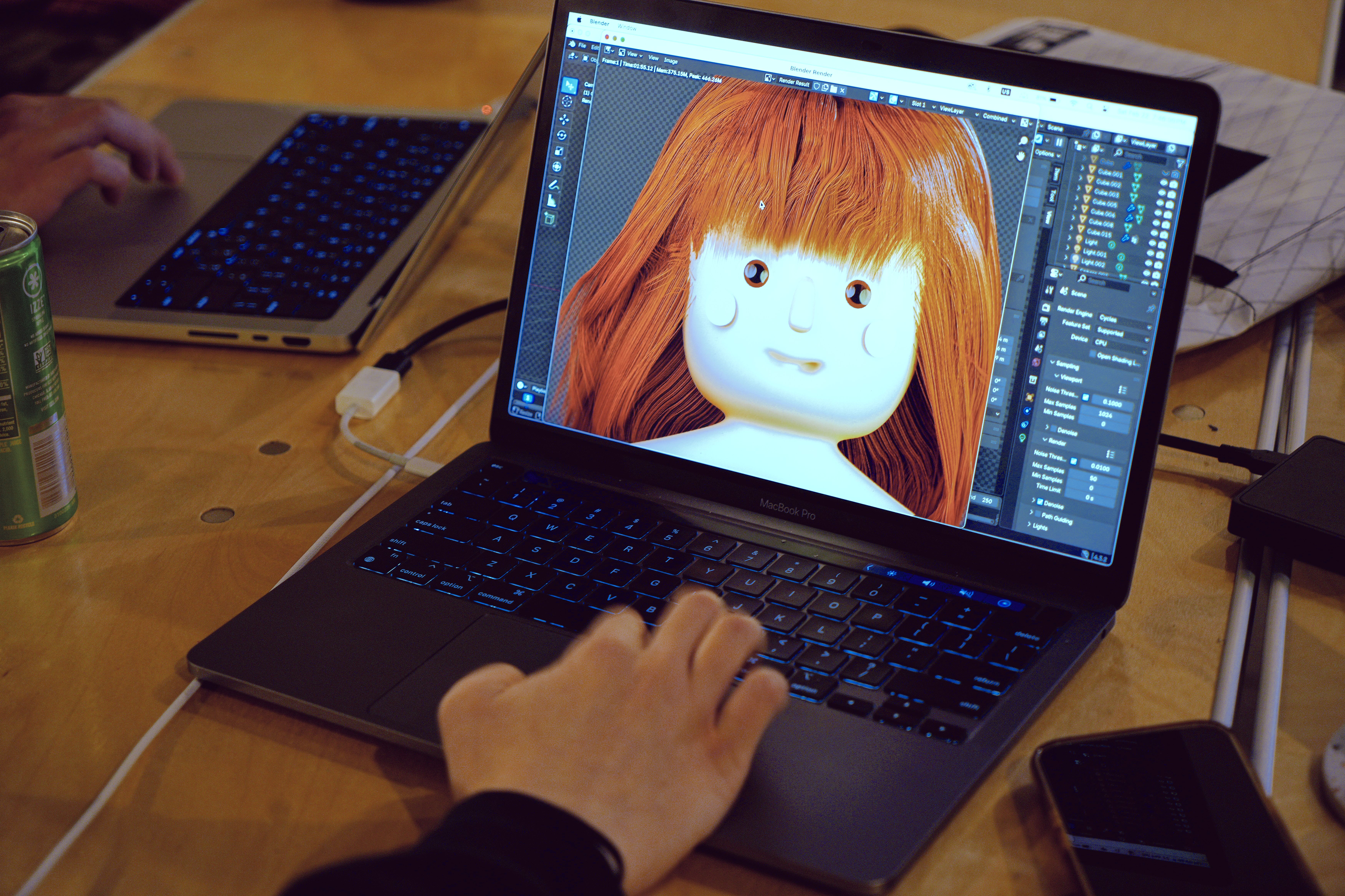 a person is typing on a laptop computer with a doll on the screen .