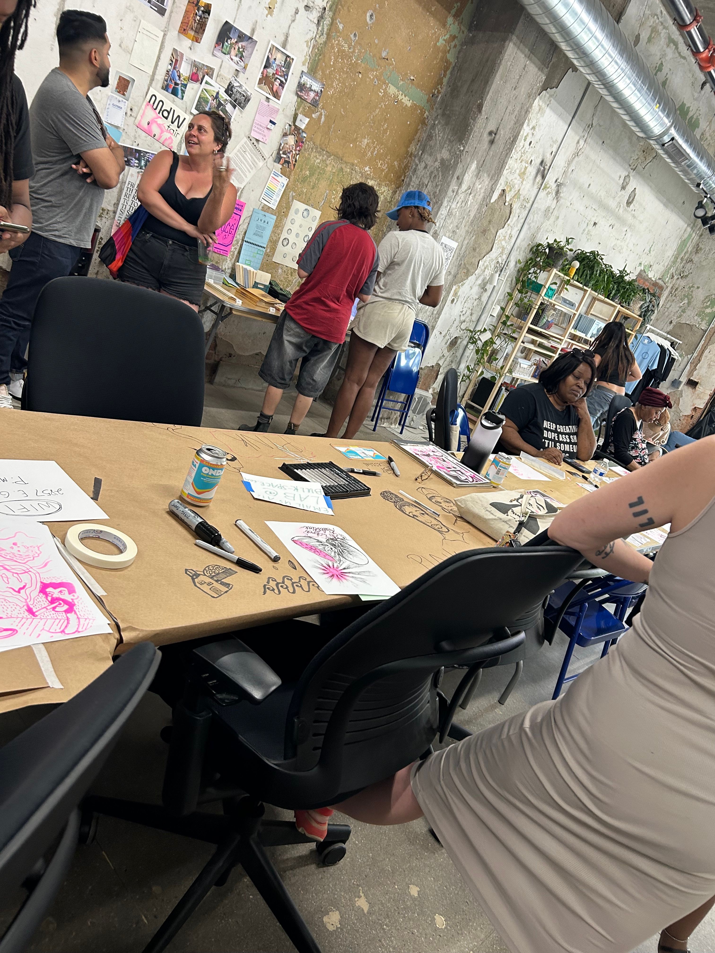 a group of people are sitting around a table with drawings on it .