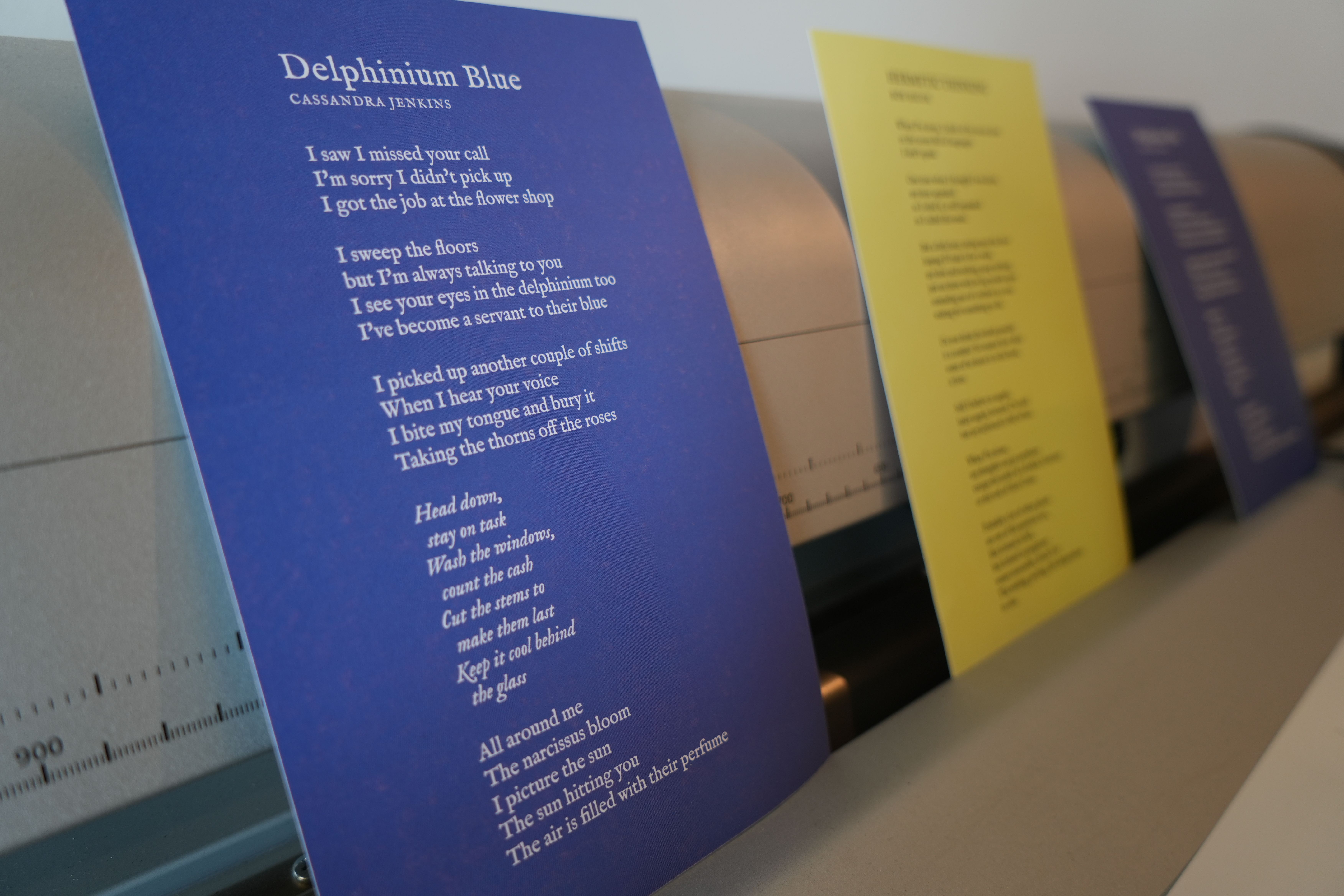 a row of papers with poems on them are sitting on a table .