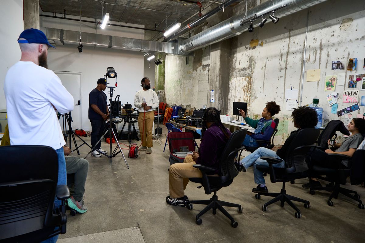 a group of people are sitting in chairs in a room .