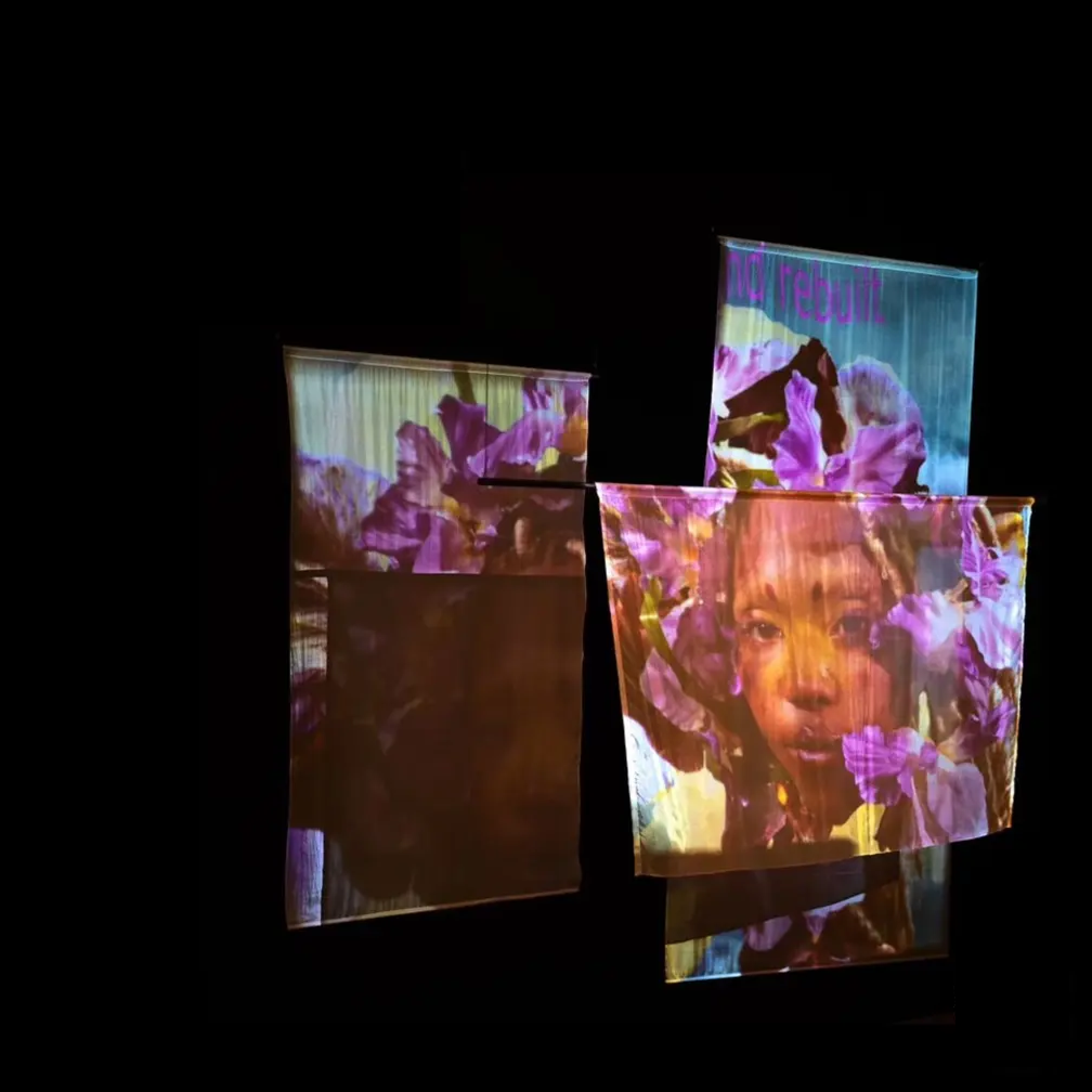 a collection of fabric with purple flowers and face projected on it