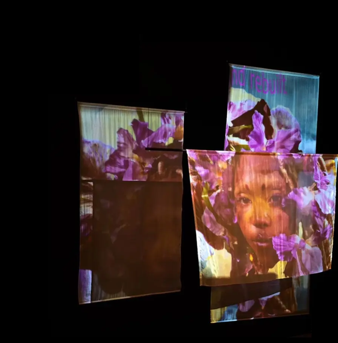 a collection of fabric with purple flowers and face projected on it