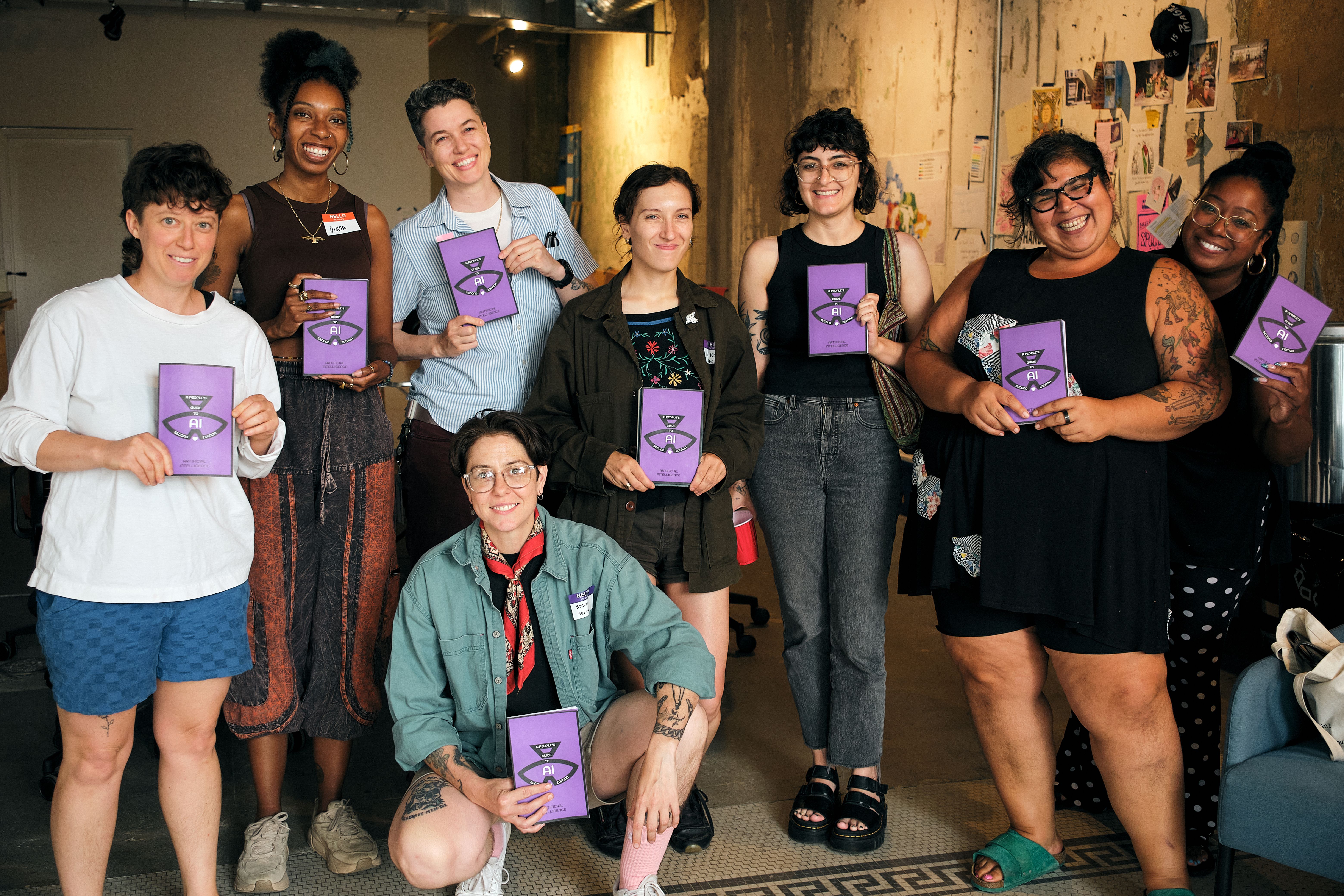 a group of women are posing for a picture while holding books .