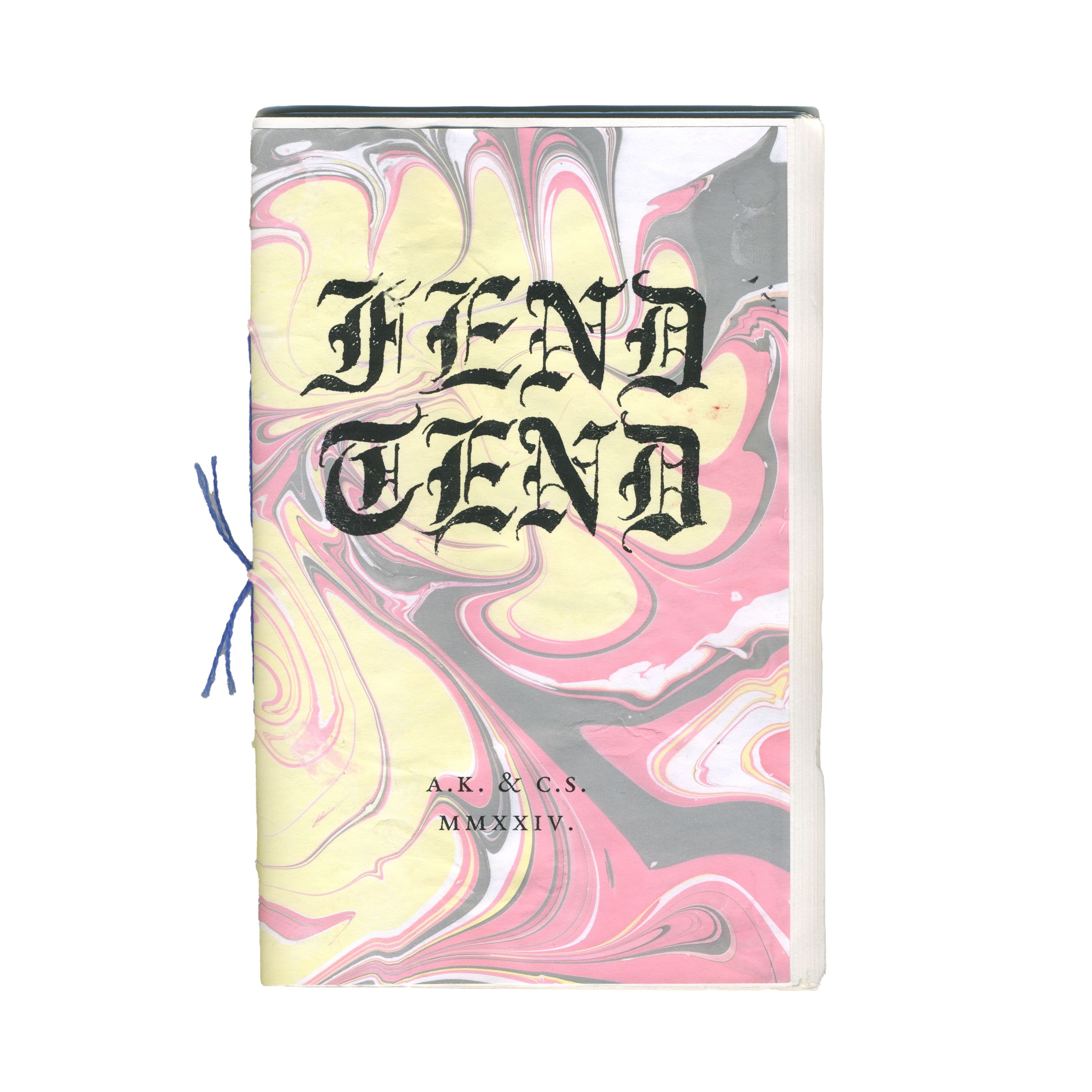 A book with a yellow, pink, gray, and white marbled cover featuring "TEND TEND" in black Gothic script, by A.K. & C.S., 2024, and bound with blue string.