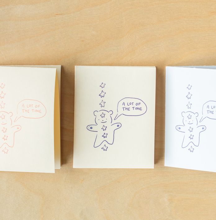 three cards with gingerbread men on them are sitting on a wooden table .
