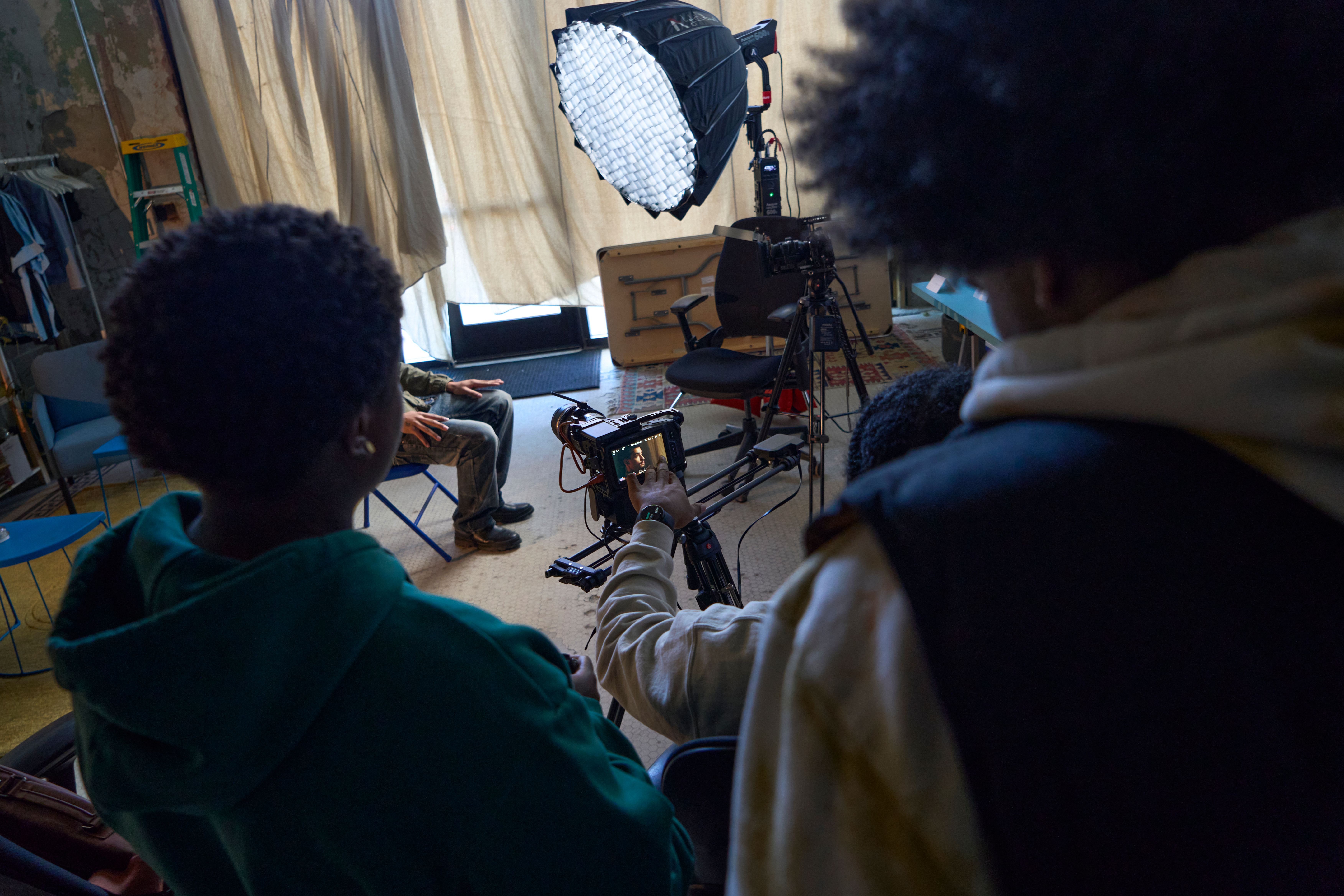 a group of young men are sitting in front of a camera in a room .
