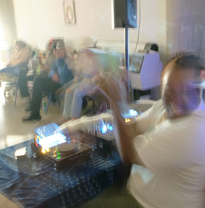 a blurry picture of a man playing using dj equipment in a room .