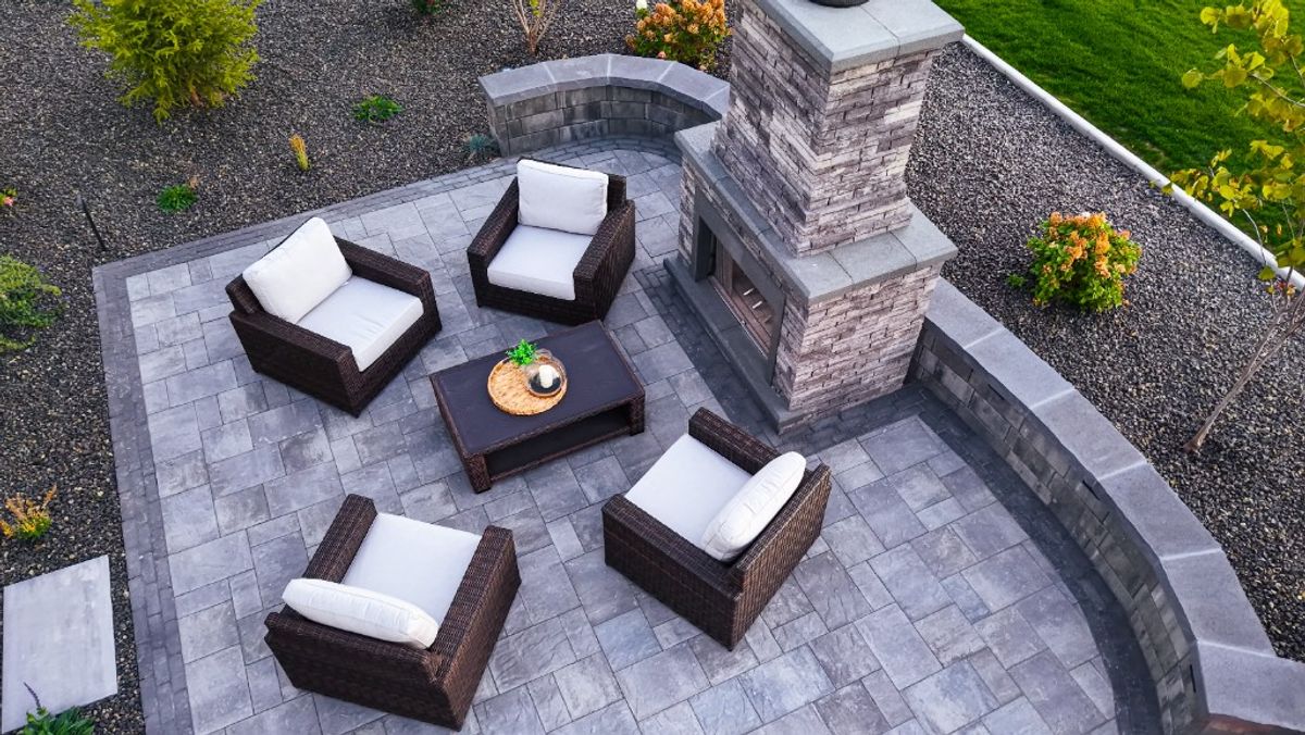 Wicker seating and a coffee table beside the stone outdoor fireplace