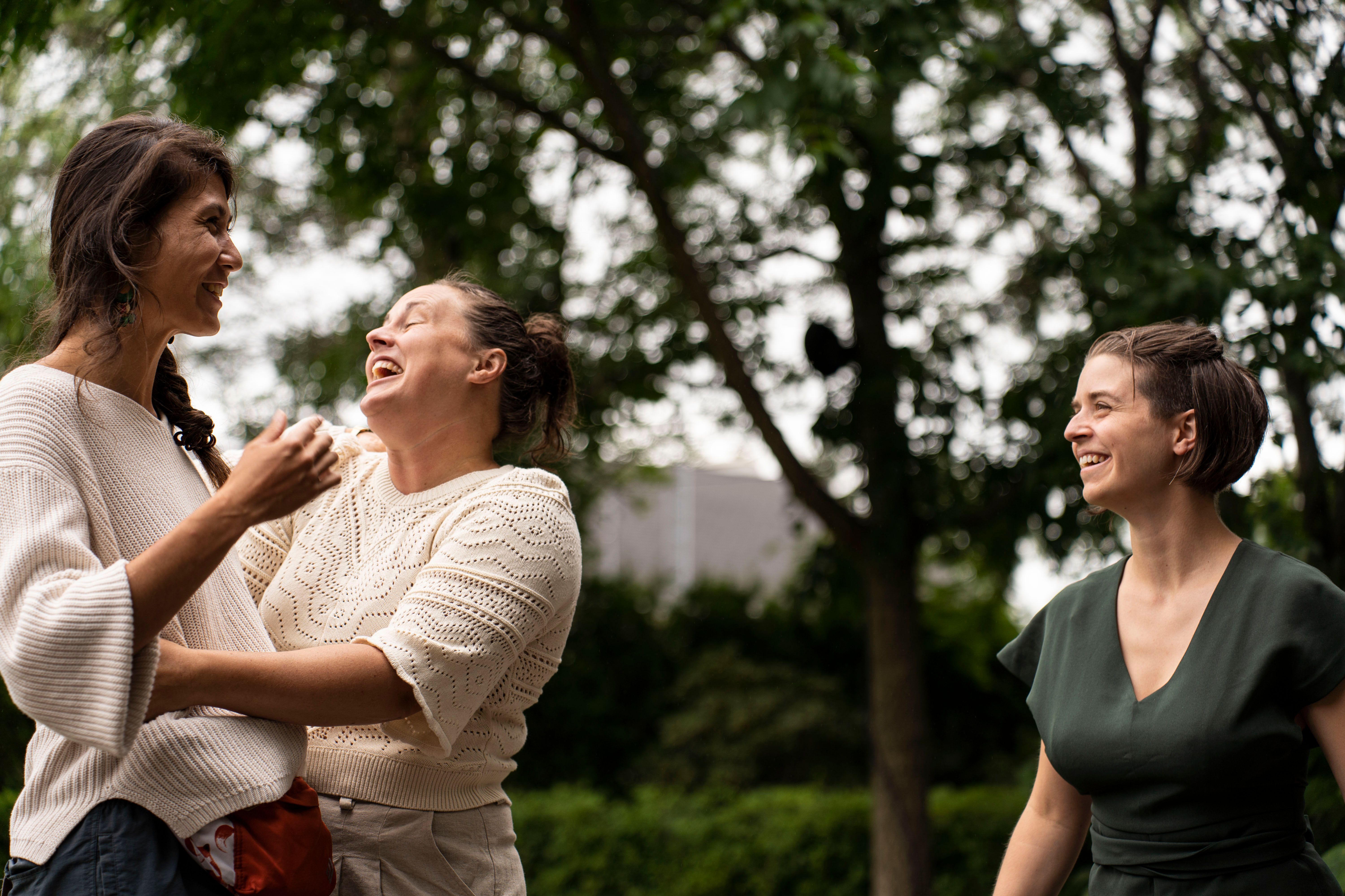 3 femmes qui rient et discutent dans un parc