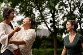 3 femmes qui rient et discutent dans un parc