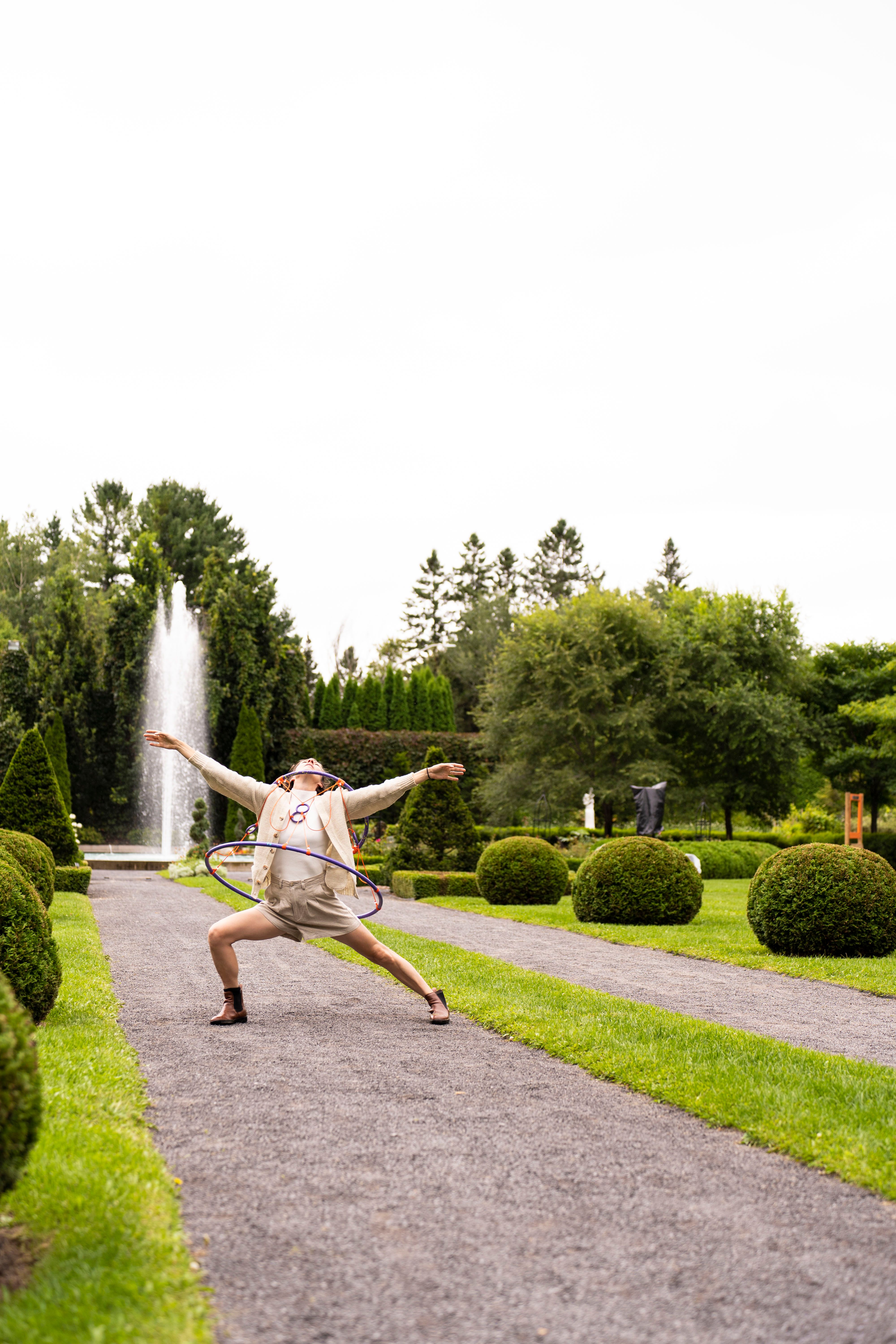 Femme devant fontaine qui fait un large mouvement de danse