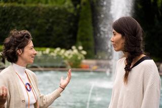 2 femmes se regardent et se parlent devant une fontaine