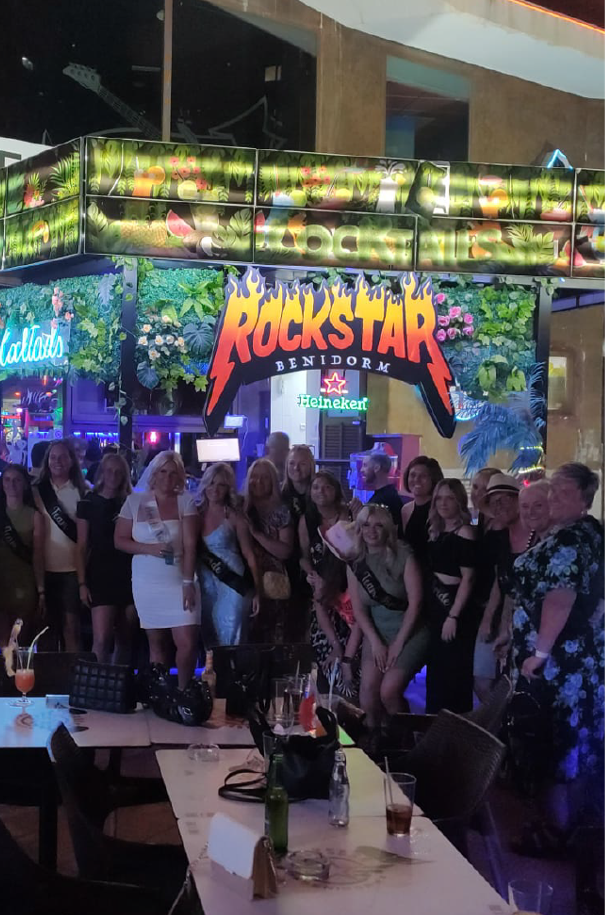 A group celebrating under the Rockstar Benidorm sign