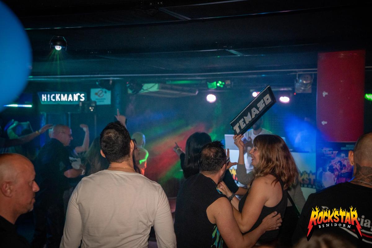 Un grupo celebrando bajo el cartel de Rockstar Benidorm