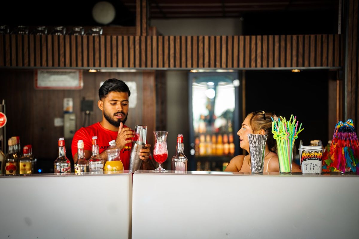 Un camarero agitando un cóctel para una clienta en la barra de Rockstar Benidorm