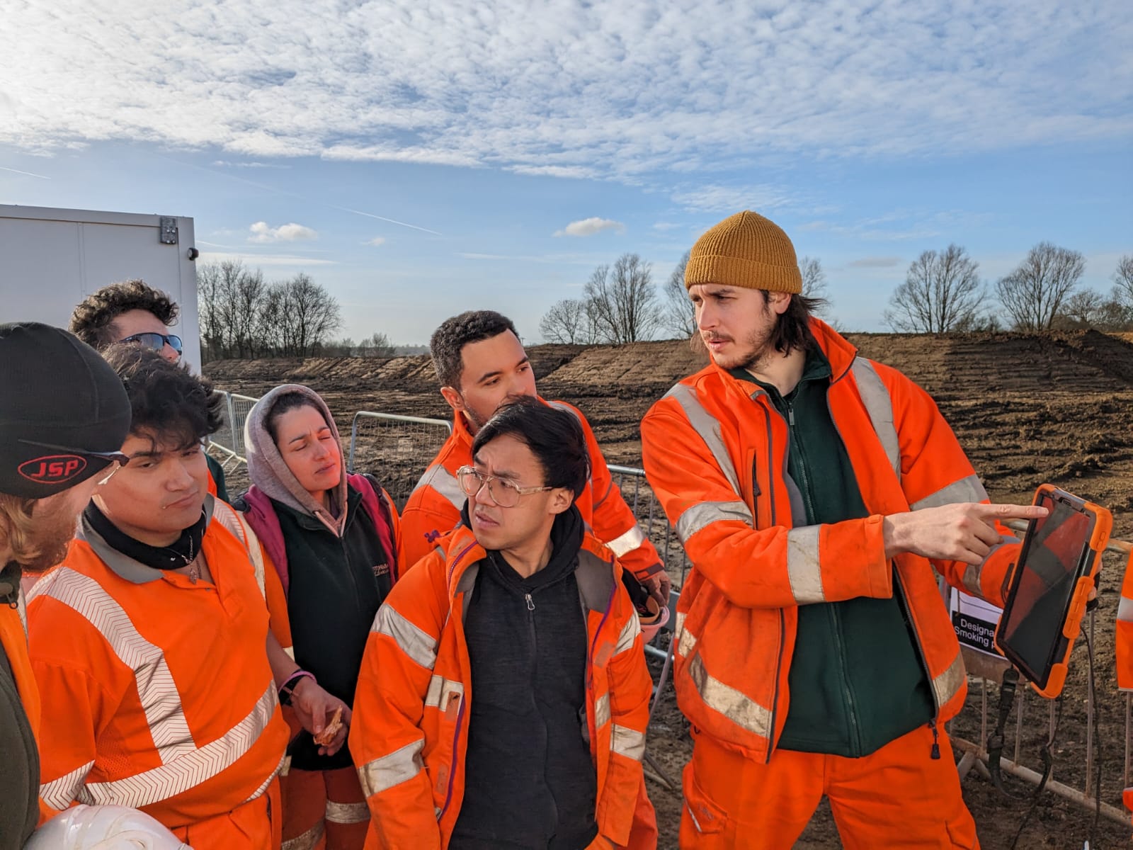 Group of people in high-visibility clothing looking at an iPad