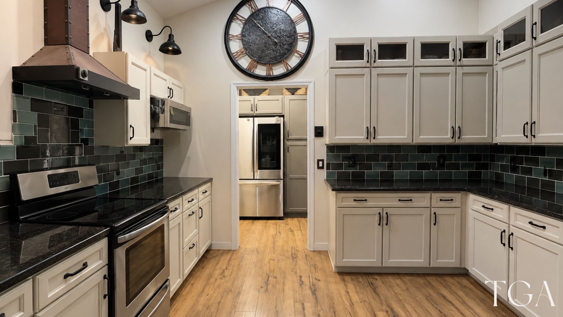 Before the Bradenton kitchen remodel: light cabinets, a dark tile backsplash and wood-look flooring