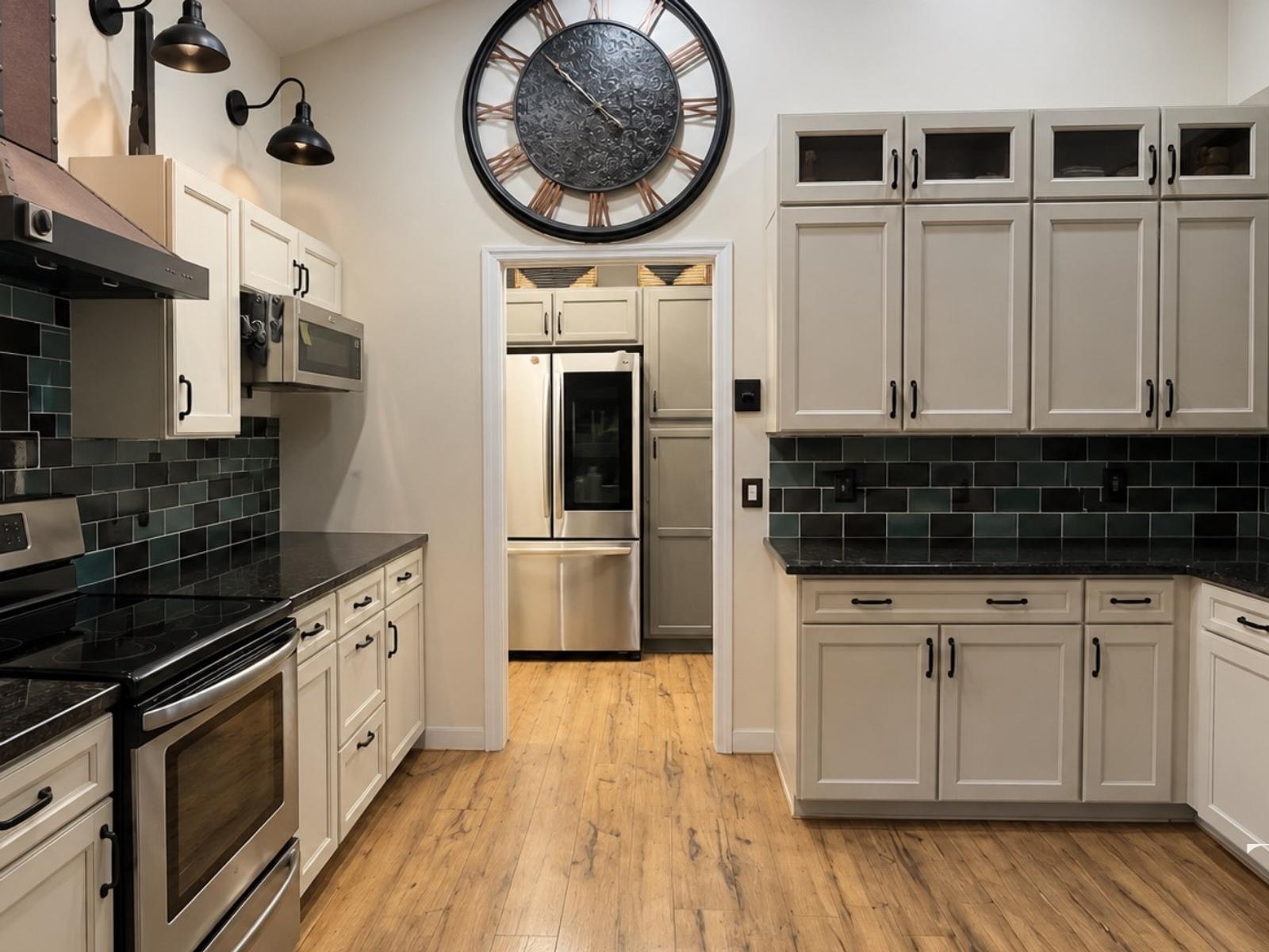 Before the Bradenton kitchen remodel: light cabinets, a dark tile backsplash and wood-look flooring