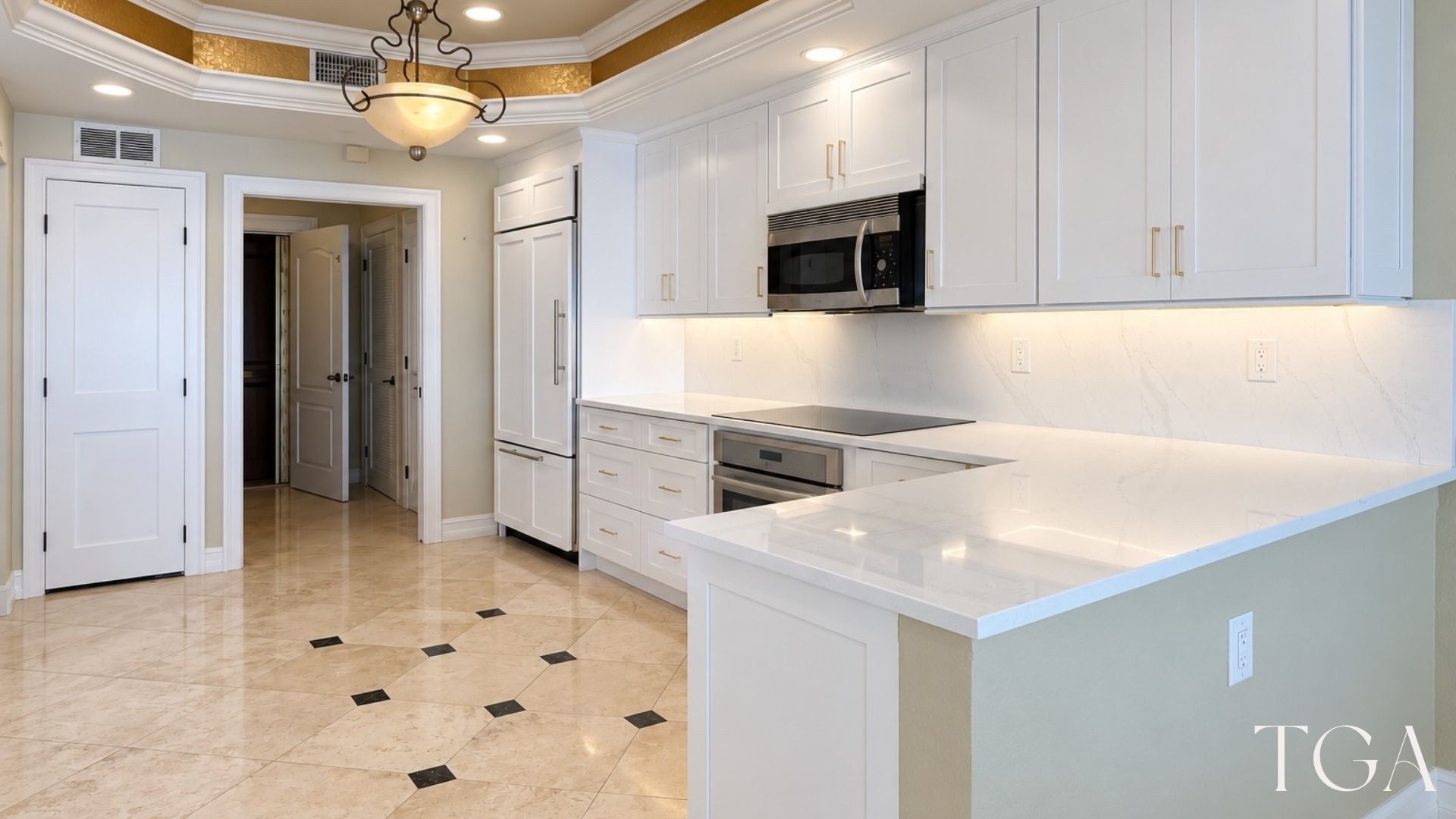 White kitchen remodel with a light counter return, wide drawers and illuminated backsplash