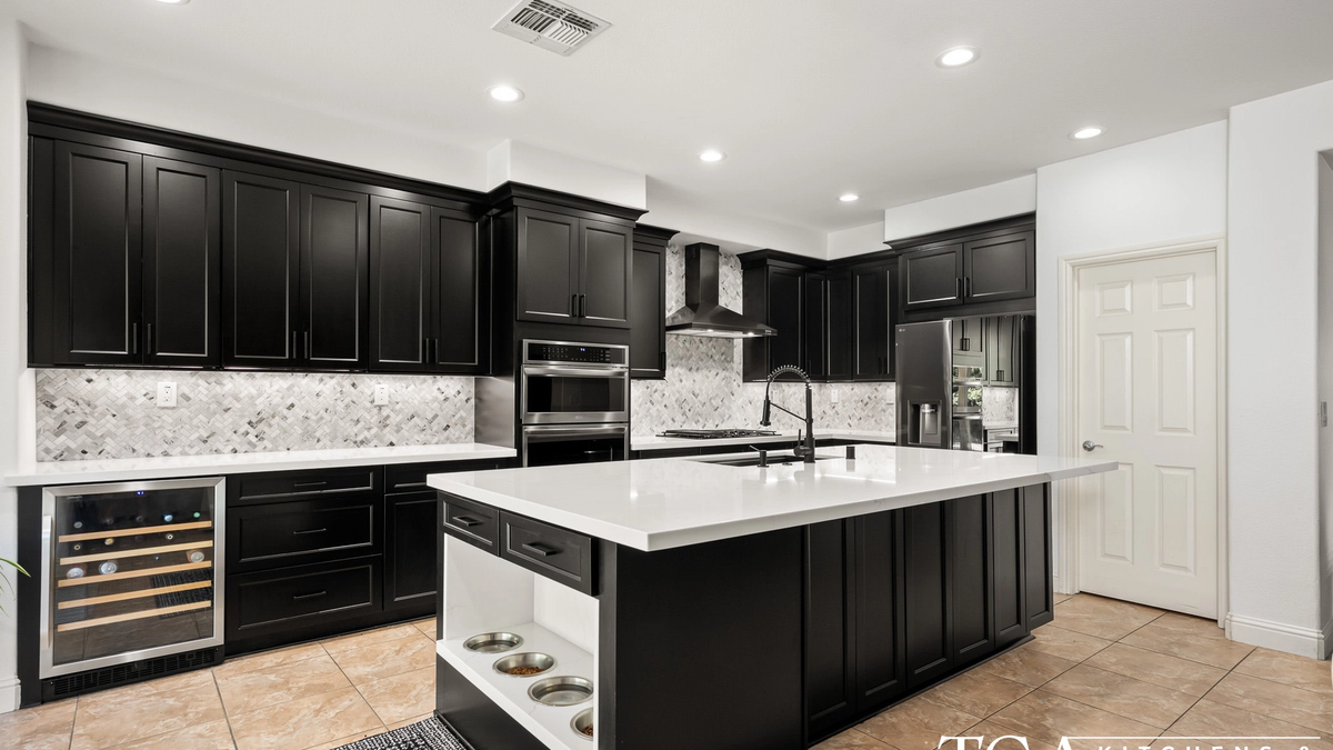 Remodeled Tampa kitchen with black shaker cabinets, white counters, and a large island