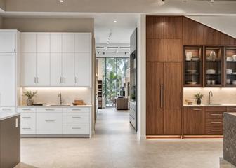 Modular white cabinets beside custom walnut cabinetry fitted to a sloped ceiling