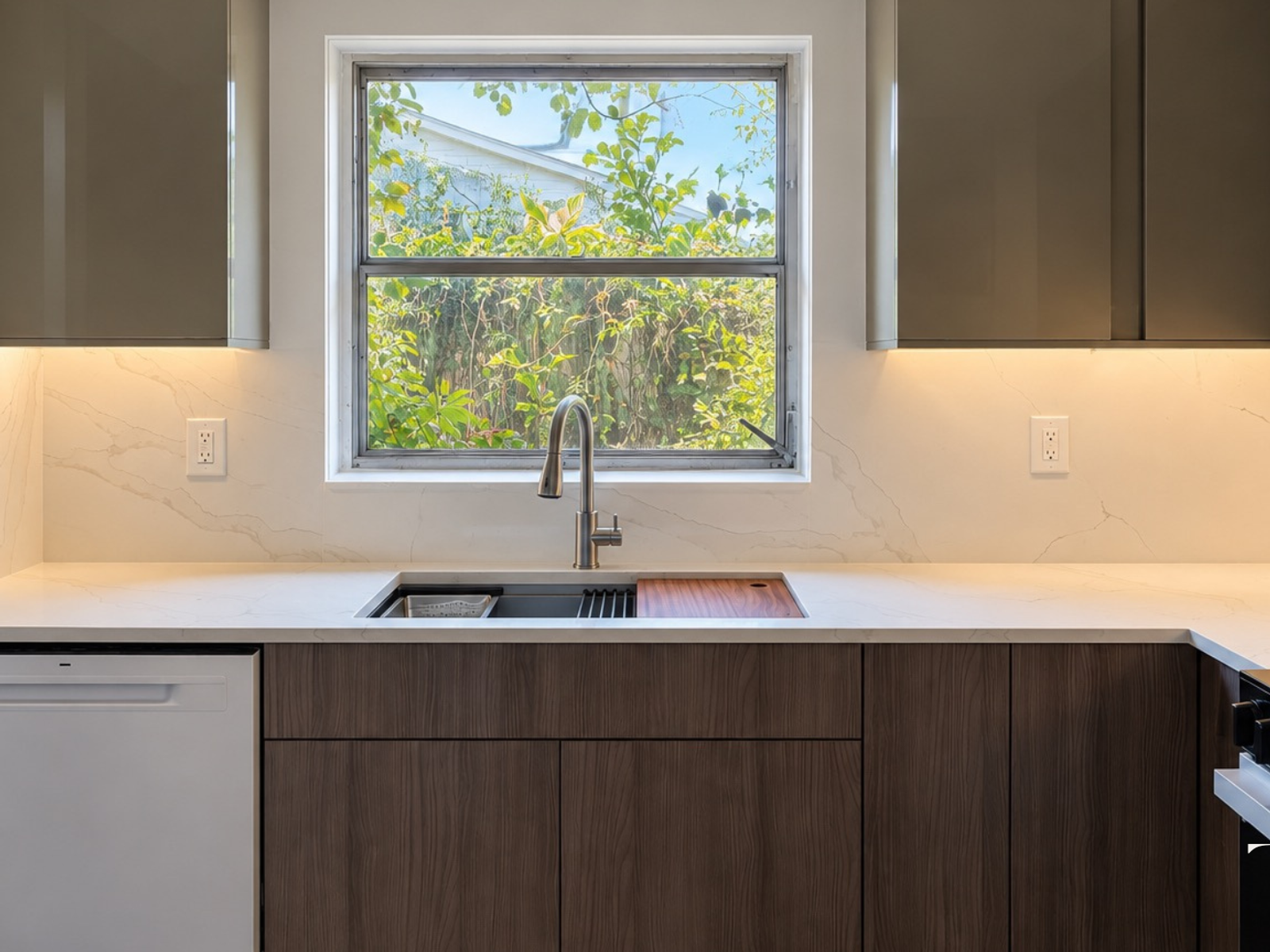 Completed two-tone kitchen sink wall with wood-grain lower cabinets and taupe upper cabinets in St. Petersburg