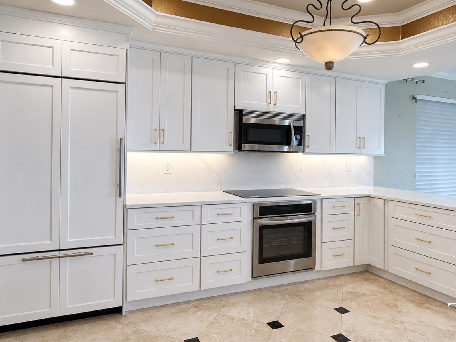 Finished white kitchen in St. Petersburg with tall cabinetry, drawer storage, a light backsplash and an oven beneath the cooktop