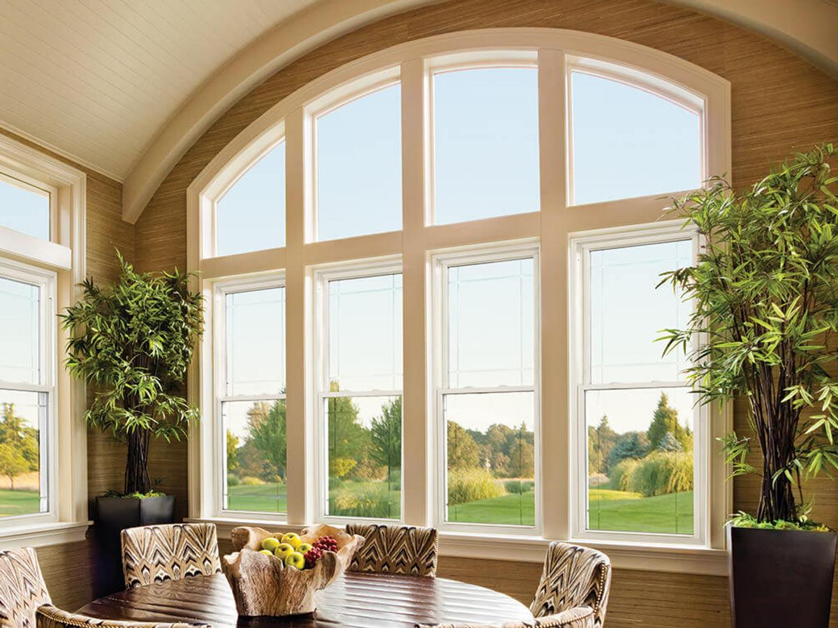 White-framed windows with an arched upper window in a bright dining room