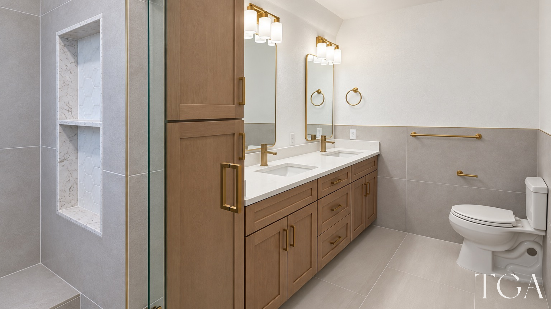 Bathroom vanity and tall storage cabinet beside a glass shower with a recessed hex-tile niche.