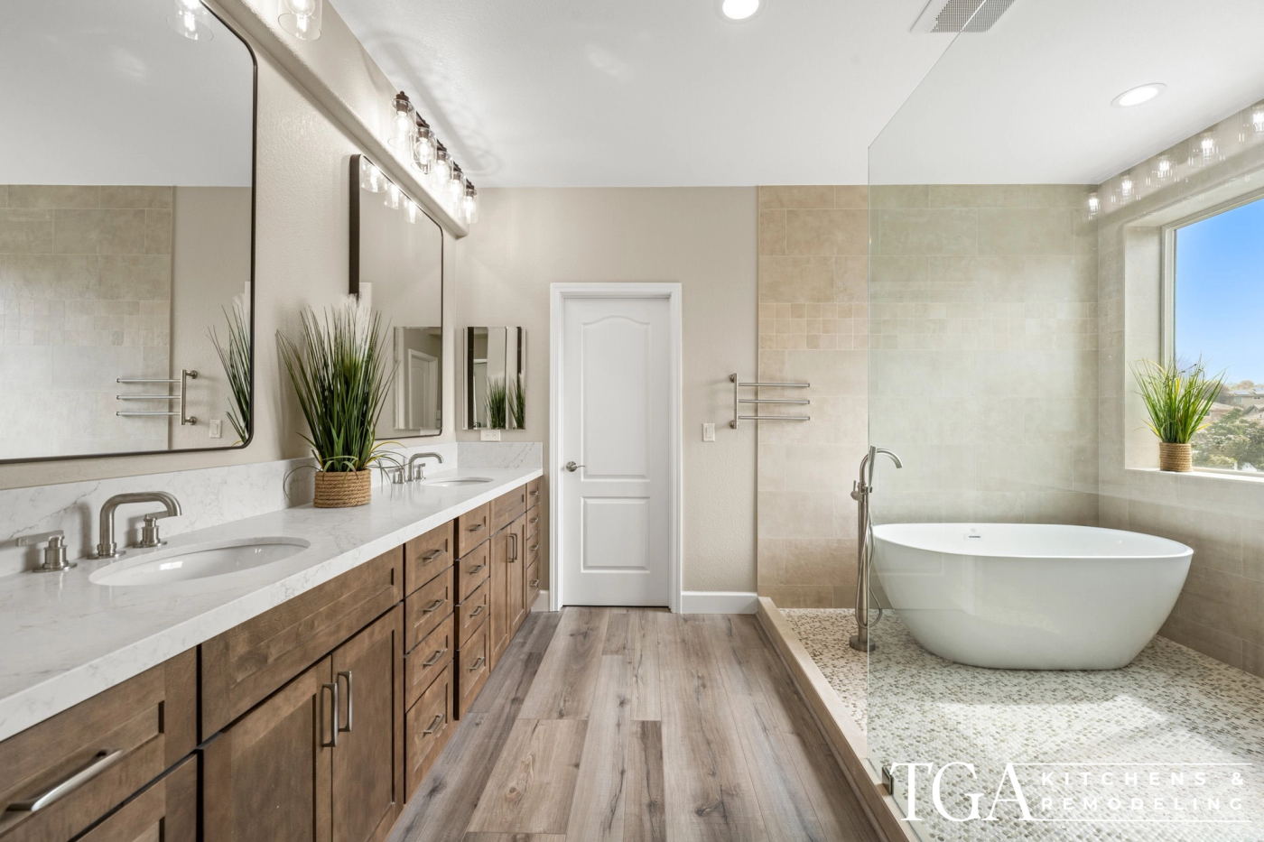 Remodeled primary bathroom in Tampa with a double wood vanity, freestanding soaker tub, and walk-in shower with pebble tile floor