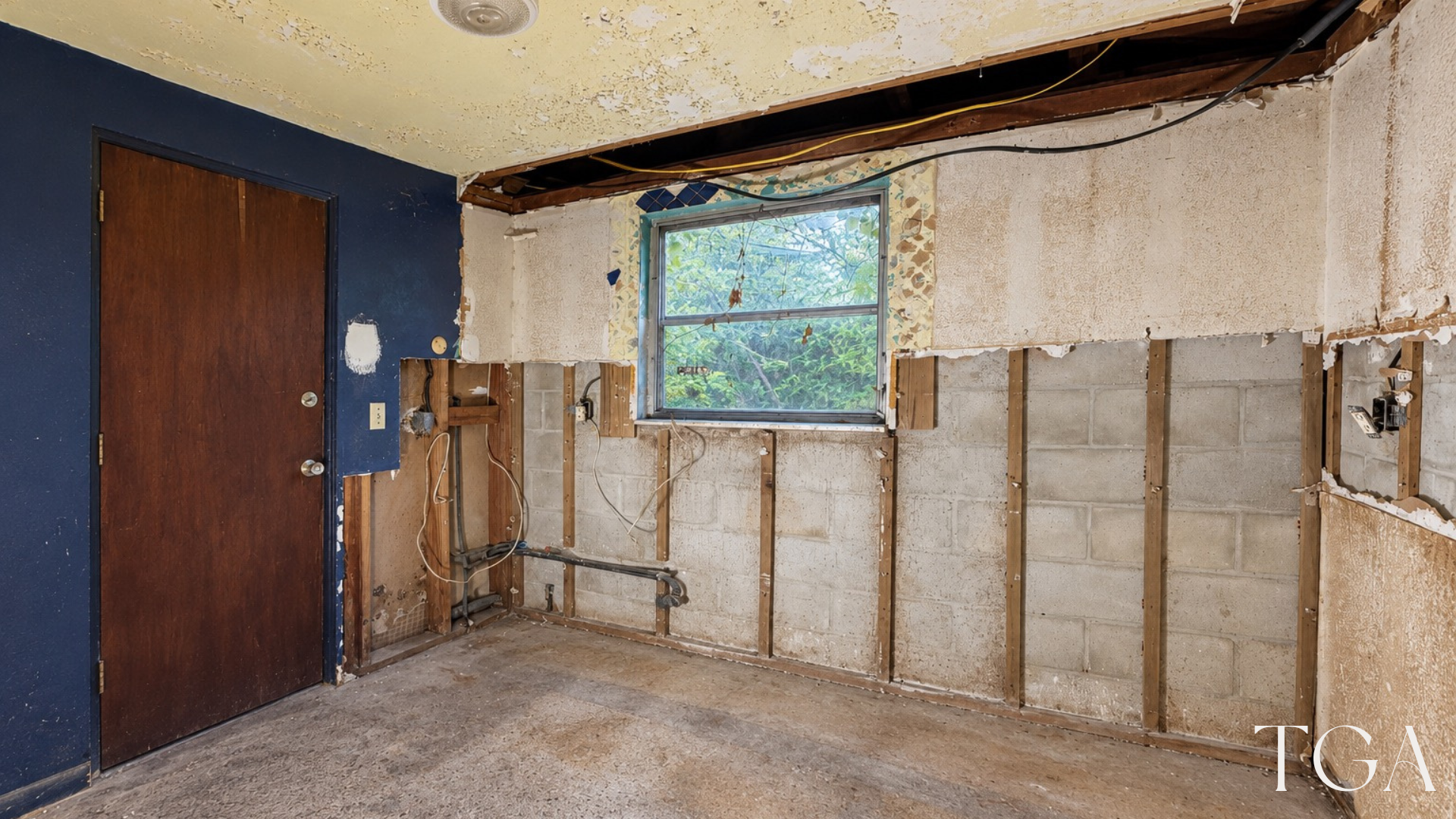 Angled view of the two-tone kitchen window wall and adjacent doorway during construction