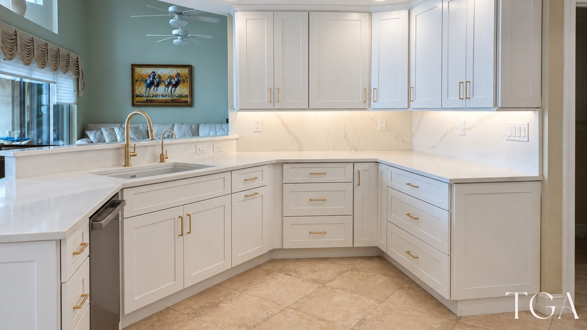 Finished kitchen sink corner with white cabinets, drawers, a gold-tone faucet and under-cabinet lighting