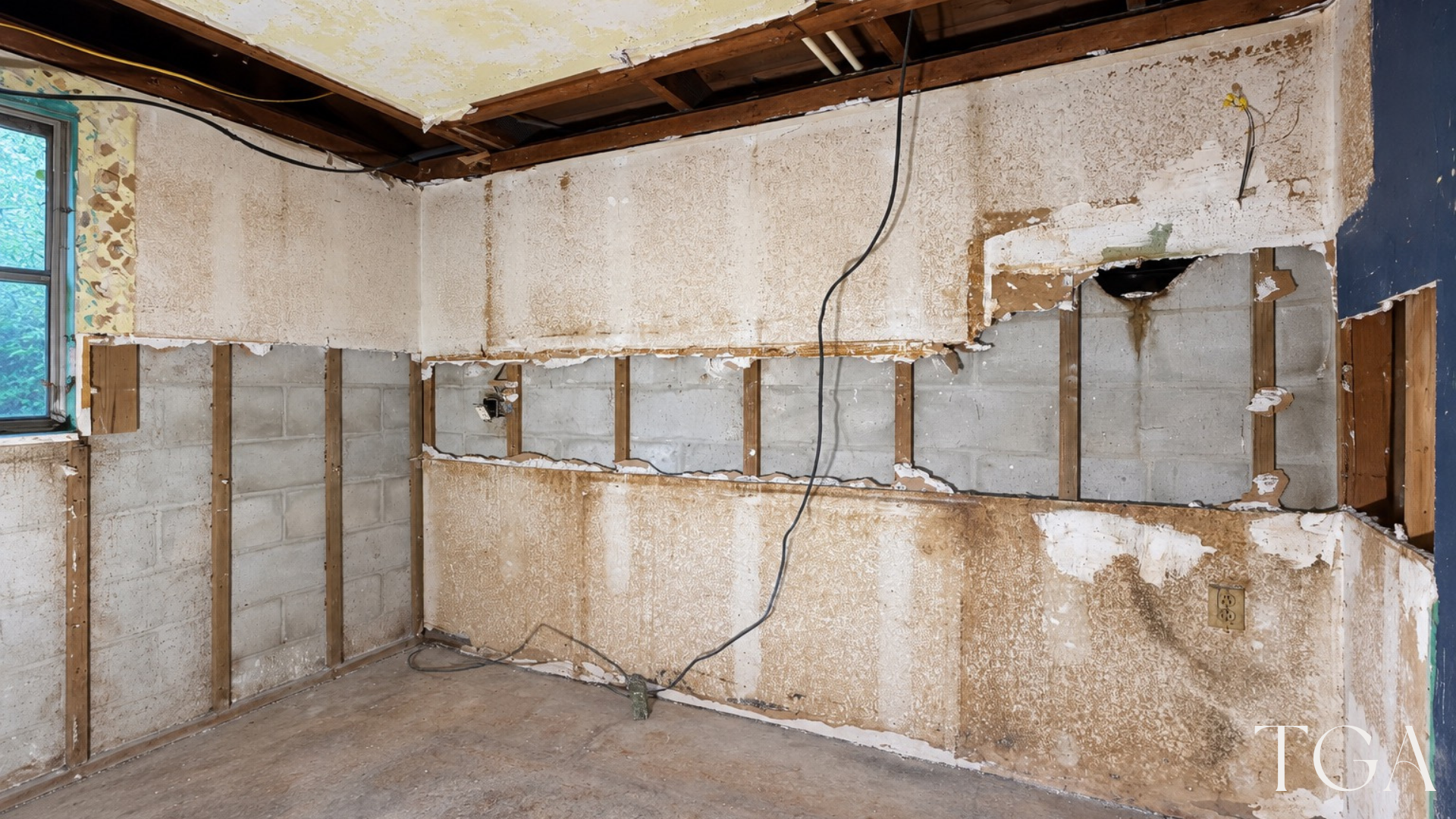 Corner of the two-tone kitchen during construction with exposed wall framing and masonry