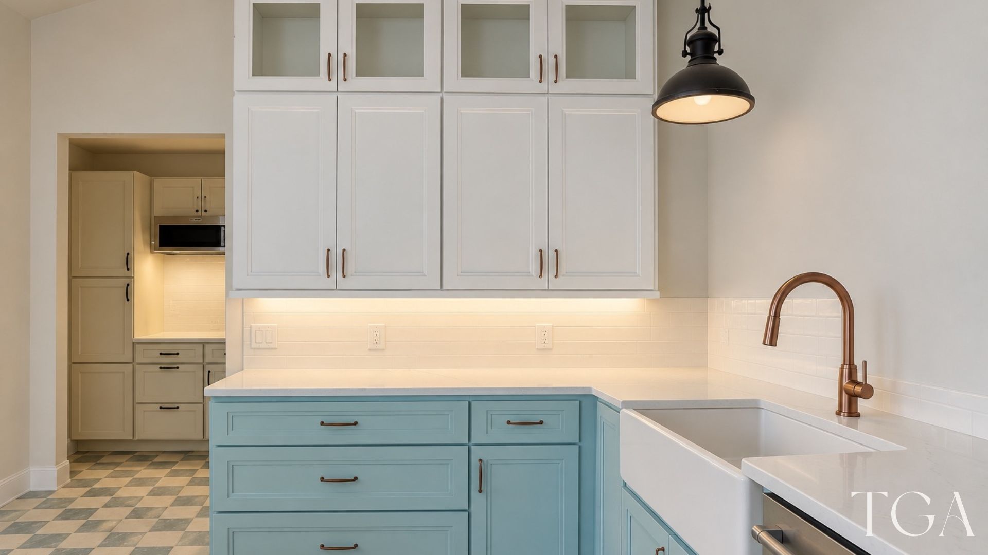 Aqua drawer cabinets beside a white apron-front sink and copper-toned faucet beneath tall white upper cabinets