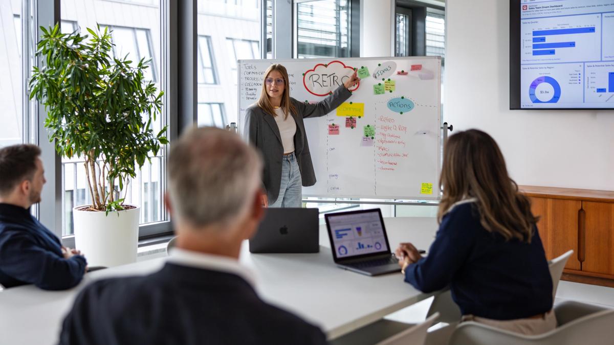 Salesfive Teammitglieder in Meetingraum während einer Präsentation