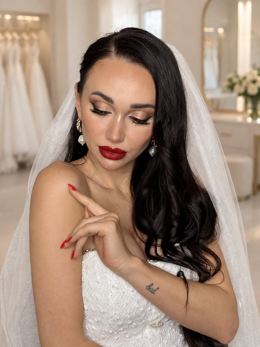 Brunette woman with glossy side-swept waves, winged eye makeup, and red lipstick.