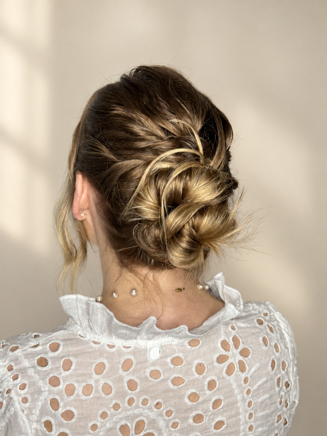 Back view of blonde hair styled in an intricate braided updo.