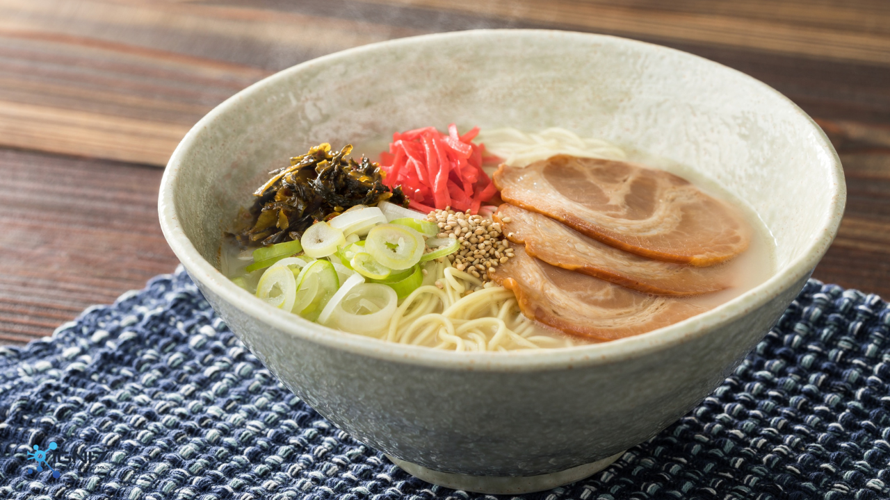 Tonkotsu ramen with chashu pork, green onions, and red pickled ginger on a blue mat