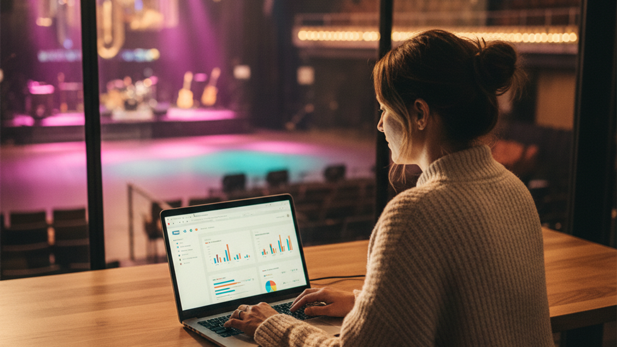 Venue operator using email marketing platform at a laptop with entertainment venue in background
