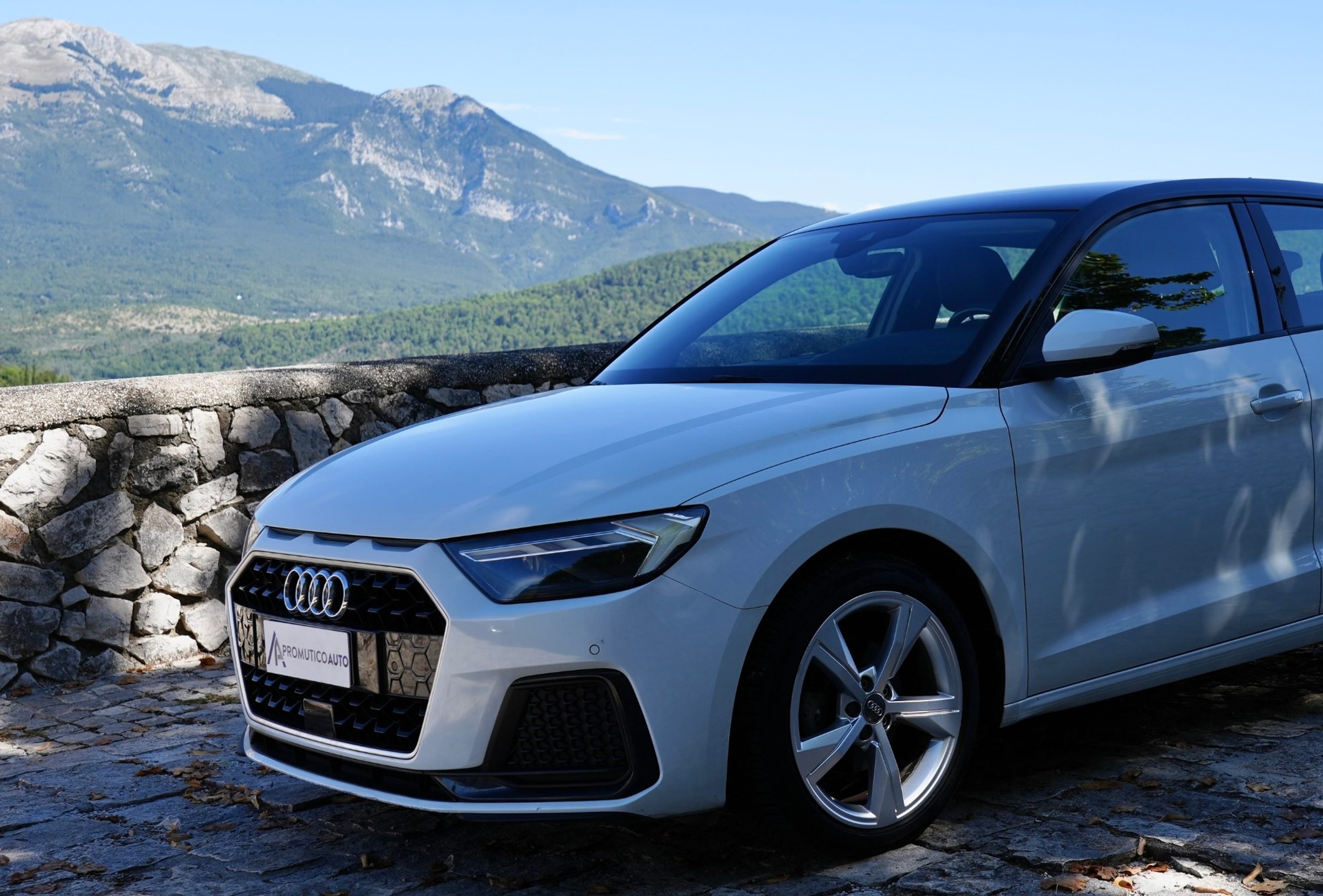 Un'Audi A1 bianca su una terrazza panoramica, con le montagne sullo sfondo