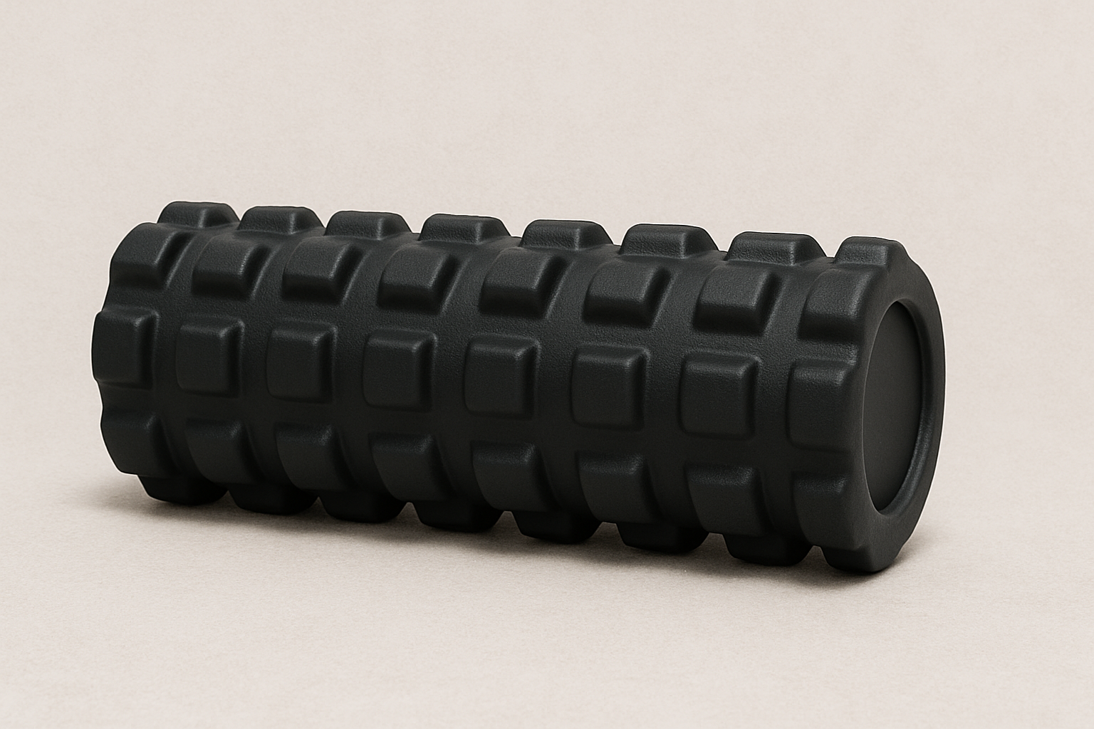 a black foam roller is sitting on a white surface