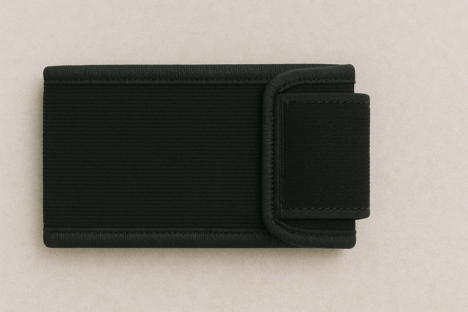 a black wallet is laying on a white surface