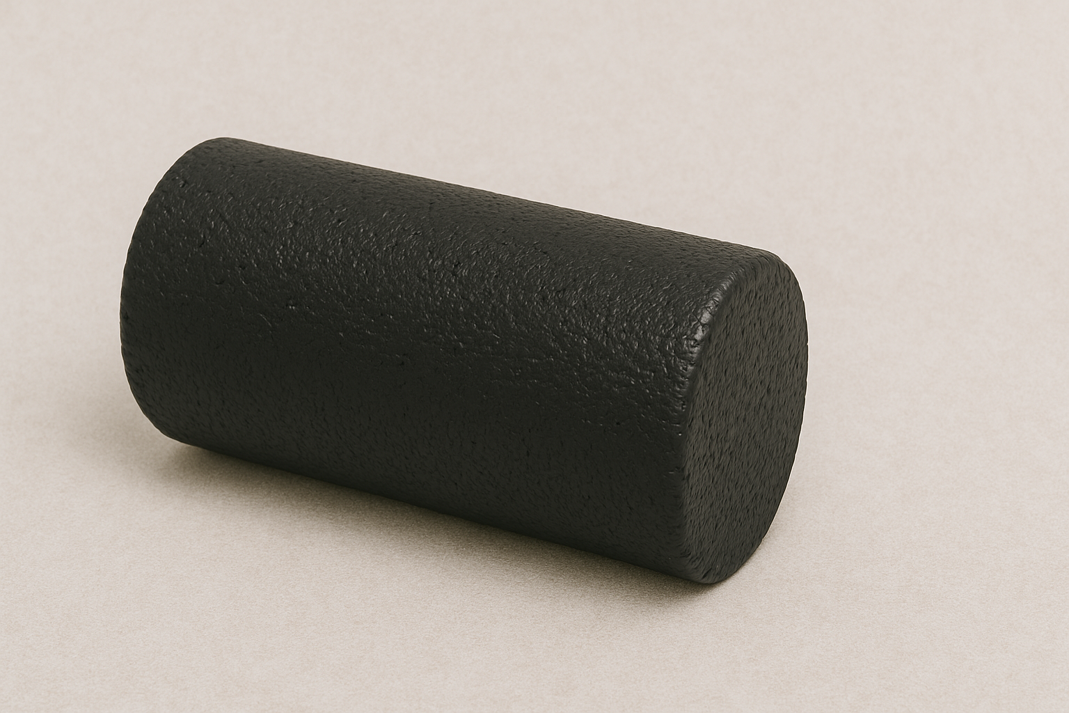 a black foam roller is sitting on a white surface