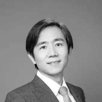 a black and white photo of a man in a suit and tie .