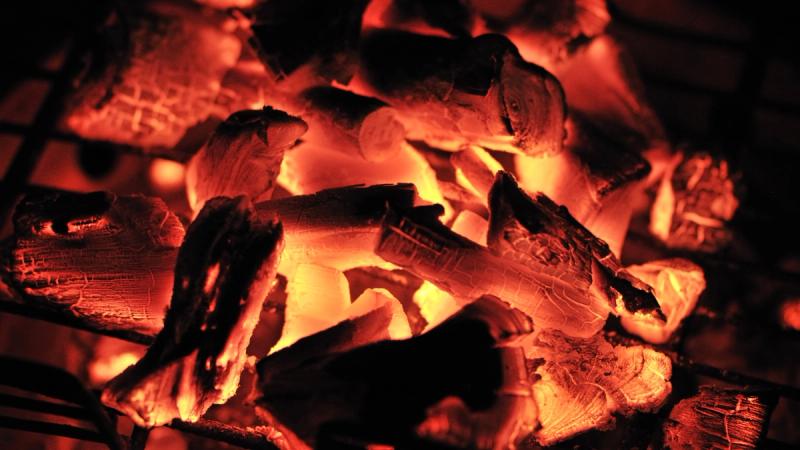 Burning charcoal briquettes with visible ash residue